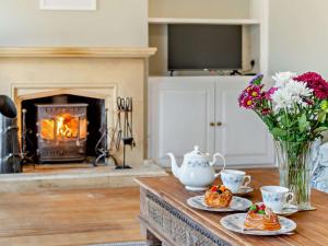 a living room with a table with desserts and a fireplace at 2 Bed in Mickleton 93980 in Mickleton