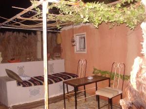 a room with a bed and a table and chairs at Maison Proche De Désert Douz in Douz