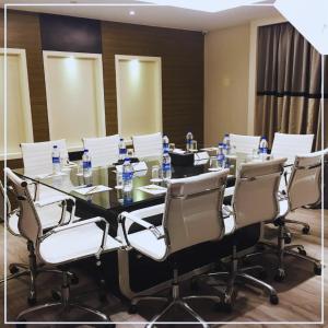 a long table with chairs and bottles of water on it at The Empresa Hotel in Mumbai