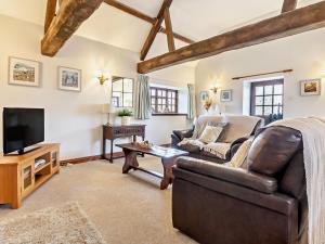 a living room with a leather couch and a tv at 2 Bed in Brighstone 94031 in Brighstone