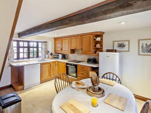 a kitchen with a table and a white refrigerator at 2 Bed in Brighstone 94031 in Brighstone