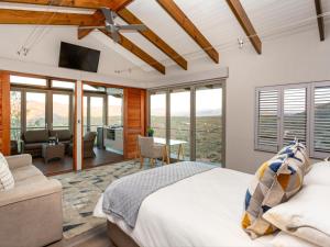 a bedroom with a bed and a living room at LANDRANI Luxury Self-catering Accommodation in Oudtshoorn