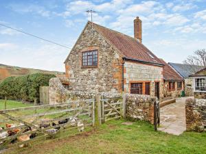 an old stone house with a fence in front of it at 2 Bed in Brighstone 94031 in Brighstone