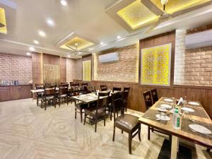 a dining room with wooden tables and chairs at Hotel Janaki ! Varanasi ! fully-Air-Conditioned-hotel family-friendly-hotel, near-Kashi-Vishwanath-Temple and Ganga ghat in Varanasi