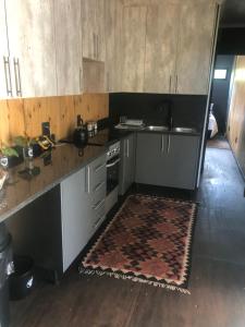 a kitchen with a counter and a sink and a rug at Hagedis Dorp - 1 Bedroom Apartment in Hartbeespoort