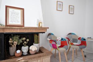 een woonkamer met 2 stoelen en een open haard bij Silenziosa Luna in Recanati