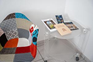 雷卡納蒂的住宿－Silenziosa Luna，坐在玻璃桌旁的椅子上,带书