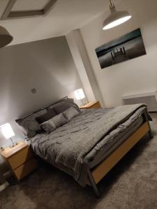 a bedroom with a bed with two night stands and two lamps at Casa de Canada Court in Glasgow