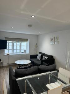 a living room with a couch and a table at West Street Mews - Serviced Accommodation in Exeter