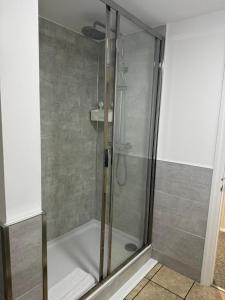 a shower with a glass door in a bathroom at West Street Mews - Serviced Accommodation in Exeter