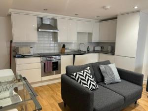 a living room with a couch and a kitchen at West Street Mews - Serviced Accommodation in Exeter