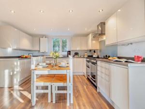 a kitchen with white cabinets and a wooden table at 2 Bed in Aberaeron 94044 in Henfynyw Upper