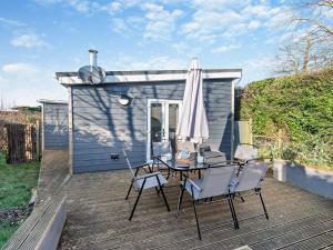 a patio with a table and chairs and an umbrella at 2 Bed in Aberaeron 94044 in Henfynyw Upper