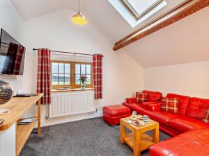 a living room with a red couch and a table at 2 Bed in Clun 94099 in Clun