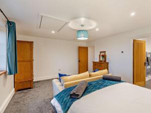 a bedroom with a large bed and a couch at 2 Bed in Clun 94099 in Clun