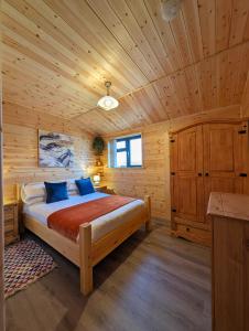 een slaapkamer met een bed in een houten hut bij Ferry Lodge in Brundall