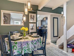 un comedor con una mesa con un jarrón de flores en 2 Bed in Buxworth 94131 en Buxworth