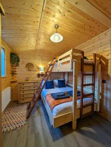 a bedroom with two bunk beds in a log cabin at Ferry Lodge in Brundall