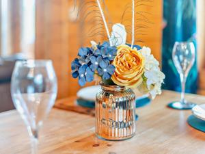 eine Vase mit Blumen auf einem Tisch mit Brille in der Unterkunft 2 Bed in Kibworth Harcourt 94141 in Market Harborough