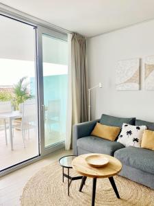 a living room with a couch and a table at Fantastic apartment in The Wave just steps from Carvajal Beach - Pool and free parking in Fuengirola