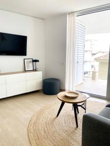 a living room with a tv and a coffee table at Fantastic apartment in The Wave just steps from Carvajal Beach - Pool and free parking in Fuengirola