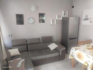 a living room with a couch and a table and a refrigerator at LOFT in Mezzolombardo
