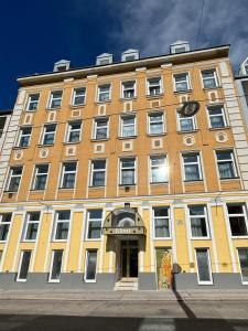ein großes gelbes und weißes Gebäude auf einer Straße in der Unterkunft Hotel Klimt in Wien