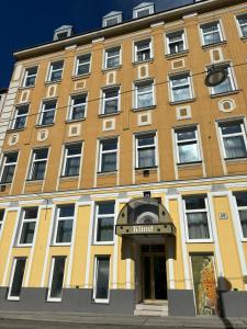 Un grand bâtiment jaune avec un million de panneaux dans l'établissement Hotel Klimt, à Vienne