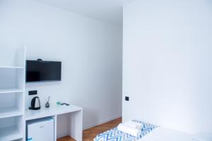 a white room with a bed and a tv at Pallada in Yerevan