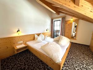een slaapkamer met een groot bed met witte kussens bij Haus Pregenzer in Fiss