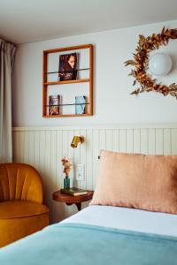 - une chambre avec un lit, une chaise et un miroir dans l'établissement Hôtel Maison Lacassagne Lyon, à Lyon