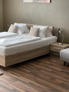 Una cama con sábanas blancas y almohadas en un dormitorio en Gästehaus Auer Fritzi, en Jois