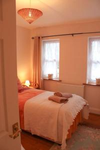 a bedroom with a bed and two windows at The Marshes - Large home, short drive to beach in Kells