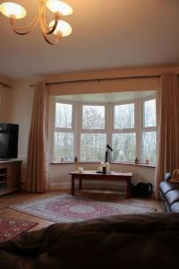 a living room with a table in front of a window at The Marshes - Large home, short drive to beach in Kells