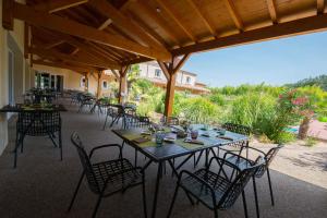 - un ensemble de tables et de chaises sur une terrasse dans l'établissement La Saleine, à Crest