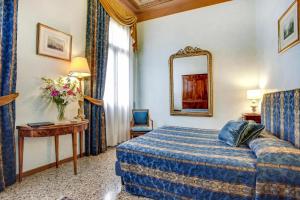 Habitación de hotel con cama y espejo en Palazzo Schiavoni Residenza d'Epoca & Suite-Apartments, en Venecia