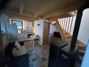 a living room with a staircase and a kitchen at Majagatt Holiday Home in Roveredo