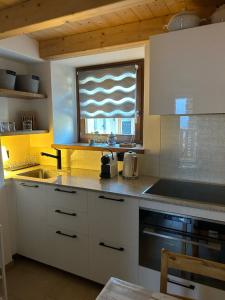 a kitchen with a sink and a window in it at Majagatt Holiday Home in Roveredo
