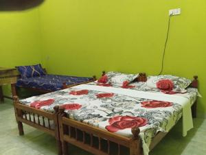 um quarto com uma cama com rosas vermelhas em Nallur mylooran Arangam em Chiviyateru West