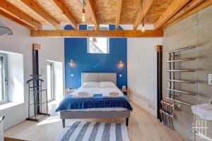 a bedroom with a bed and a blue wall at L'escapade / Maison de campagne in Veigné