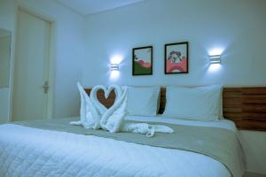 a bedroom with a white bed with two white pillows at Pousada Galemares in Maragogi