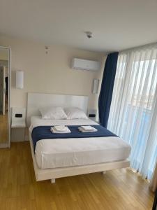 een slaapkamer met een bed met twee handdoeken erop bij ORBI city in Batoemi