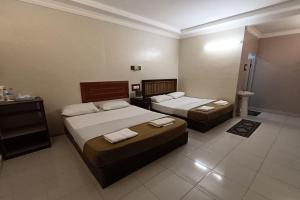 a hotel room with two beds and a bathroom at Fins Hotel, Alor Setar in Alor Setar +34 photos