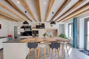 a kitchen with a large wooden table and chairs at L'escapade / Maison de campagne in Veigné