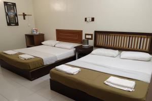 two beds in a hotel room with towels on them at Fins Hotel in Alor Setar