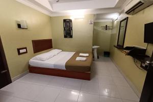 1 dormitorio con 1 cama con 2 toallas en Fins Hotel en Alor Setar