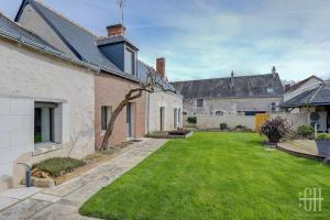 a backyard of a house with a grass yard at L'escapade / Maison de campagne in Veigné