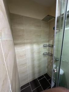 a shower with a glass door in a bathroom at Pelumi’s Studio in Lagos