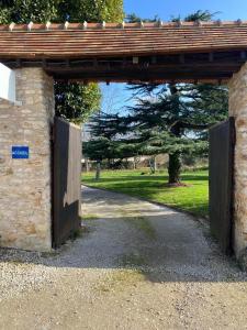 an entrance to a stone building with a wooden gate at Chambre équipée Plain-Pied - 2 pers avec sdb wc privé in Hargeville +4 photos