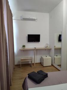 a white room with a bed and a desk with a television at Puzzle Magic in Piteşti